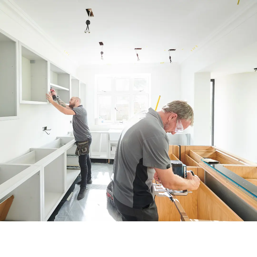 Two workers doing joinery works in kitchen